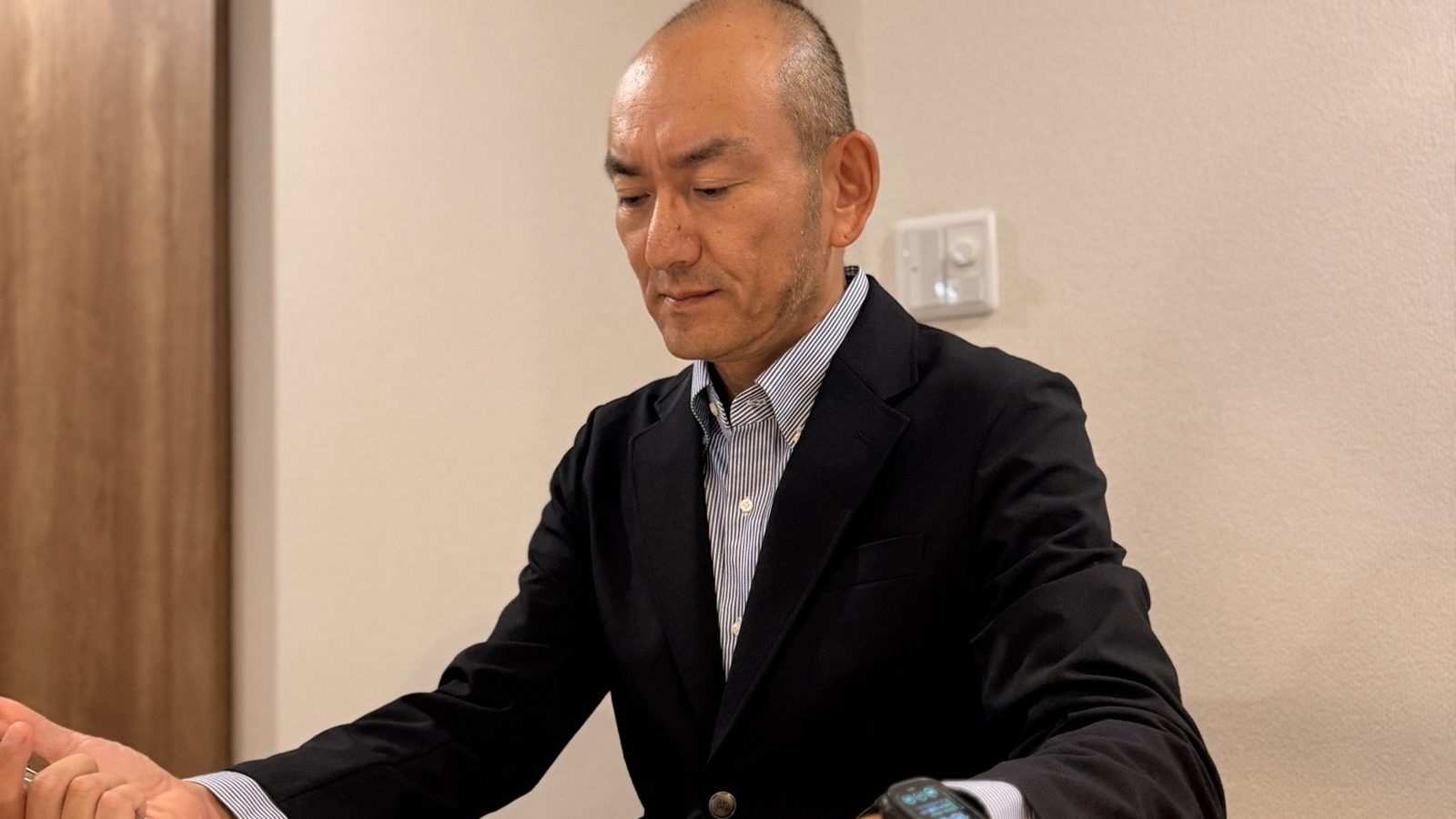 机に向かって、手元に目を落としているところ